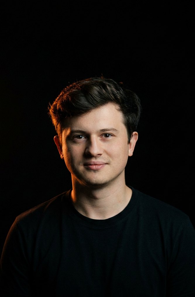 David Krasovskij, lit by a warm ember rim light against black